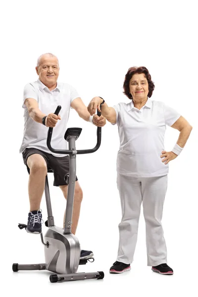 Mature Man Exercising Stationary Bike Mature Woman Leaning Isolated White — Stock Photo, Image