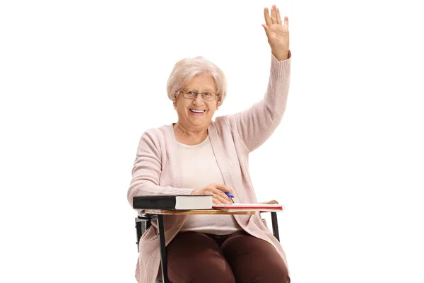 成熟的妇女抱着她的手坐在学校的椅子上孤立的白色背景 — 图库照片