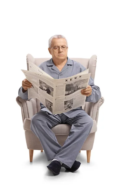 穿着睡衣的成熟男人坐在扶手椅上 阅读一份在白色背景上孤立的报纸 — 图库照片