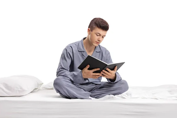 Teenager Sitzt Auf Einem Bett Und Liest Ein Buch Isoliert — Stockfoto