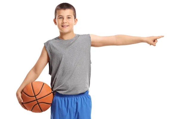 男孩拿着一个篮球和指向被隔绝在白色背景 — 图库照片