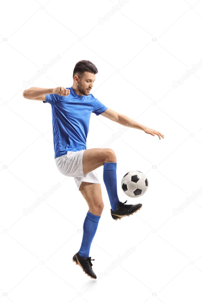 Full length profile shot of a soccer player juggling isolated on white background