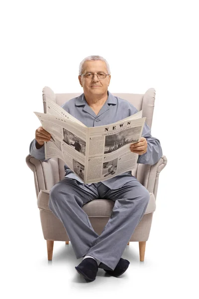 成熟的人坐在扶手椅上拿着报纸 看着在白色背景下隔离的相机 — 图库照片