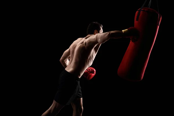 Boxeador fuerte golpeando un saco de boxeo — Foto de Stock