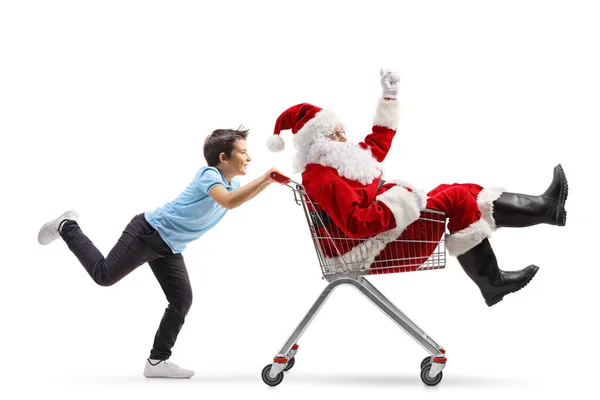 男孩把圣诞老人推上购物车 — 图库照片