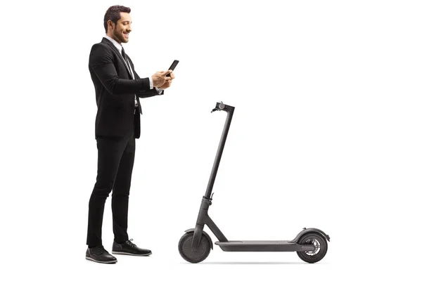 Empresario alquilando un scooter eléctrico con una aplicación de teléfono móvil — Foto de Stock