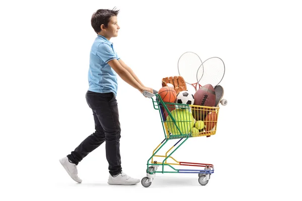 Boy walking and pushing a mini cart with sport items — Stock Photo, Image