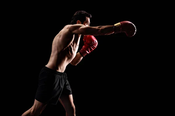 Uomo muscolare punzonatura con guanti da boxe — Foto Stock