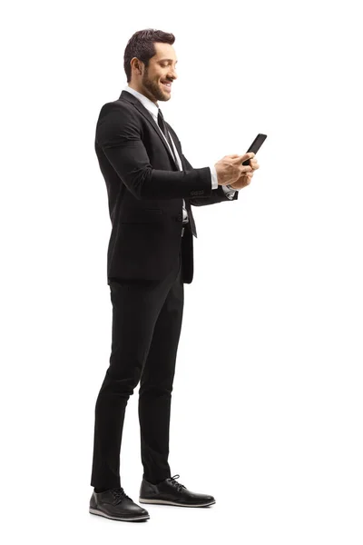 Empresario sonriendo y escribiendo en un teléfono móvil —  Fotos de Stock