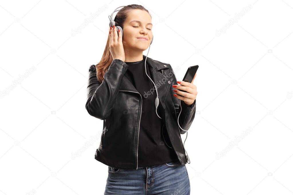 Young female listening to music on headphones and enjoying