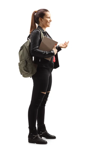 Trendy adolescente femmina con un backapck e libro gesticolando con ha — Foto Stock