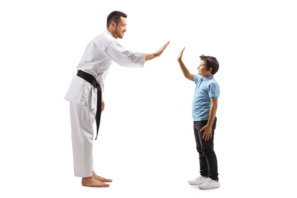 Uomo in kimono karate gesticolando il cinque con un ragazzo — Foto Stock