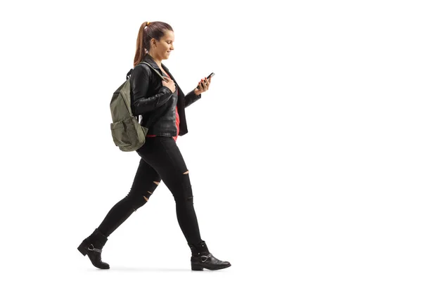 Dziewczyna z plecakiem spaceruje i patrzy na telefon komórkowy — Zdjęcie stockowe