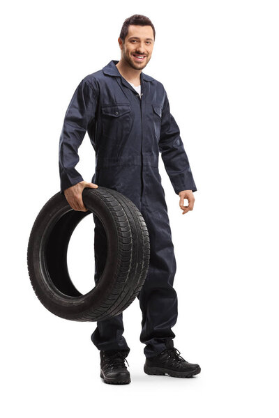 Mechanic smiling and holding a tire