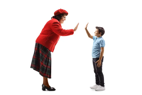 Eedlerly lady gesturing high-five with a young boy — Stock Photo, Image