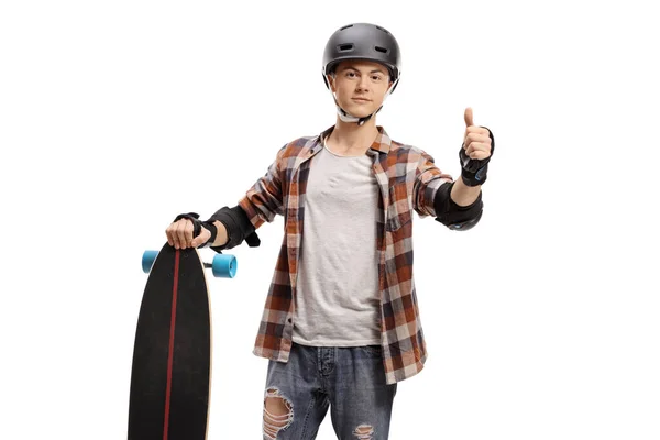 Guy with protective equipment and a longboard making a thumb up — Stock Photo, Image