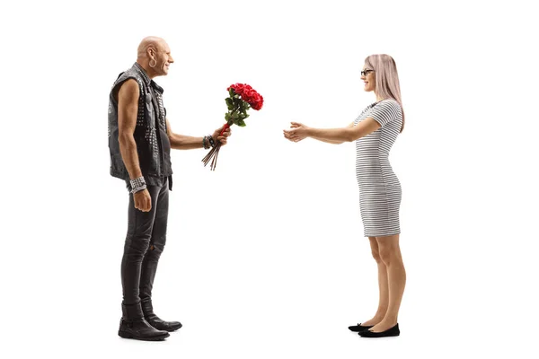 Punker geeft bloemen aan een jonge vrouw — Stockfoto