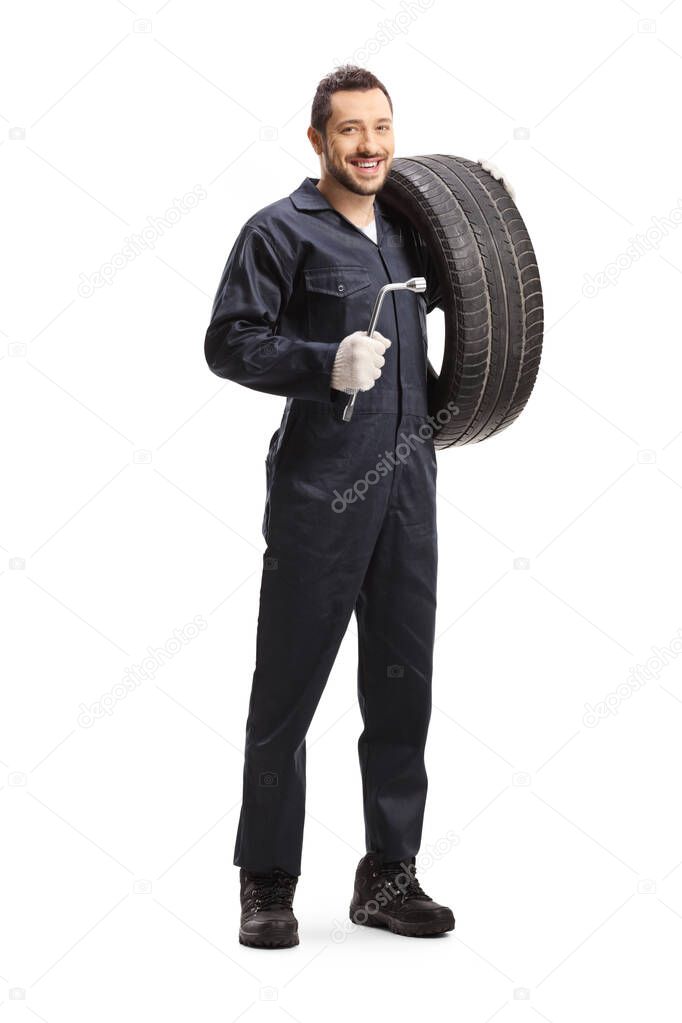 Mechanic holding a tire and a lug wrench 