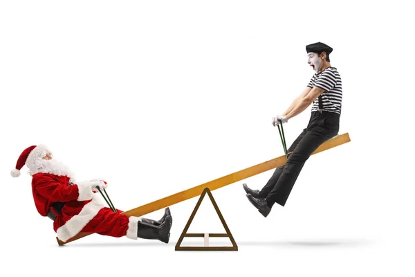 Santa Claus on a seesaw with a mime — Stock Photo, Image