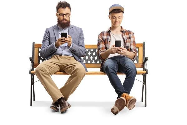 Padre e figlio adolescente con telefoni cellulari seduti su una panchina — Foto Stock