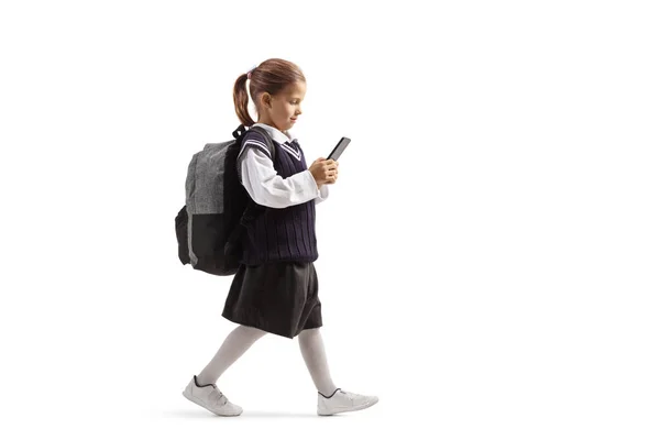 Pequena estudante andando e digitando em um smartphone — Fotografia de Stock