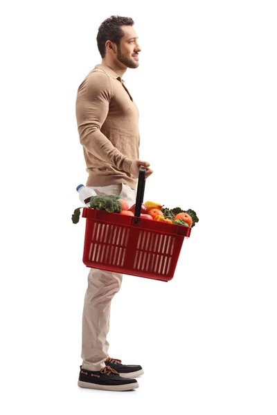 Mladý muž s nákupním košíkem — Stock fotografie