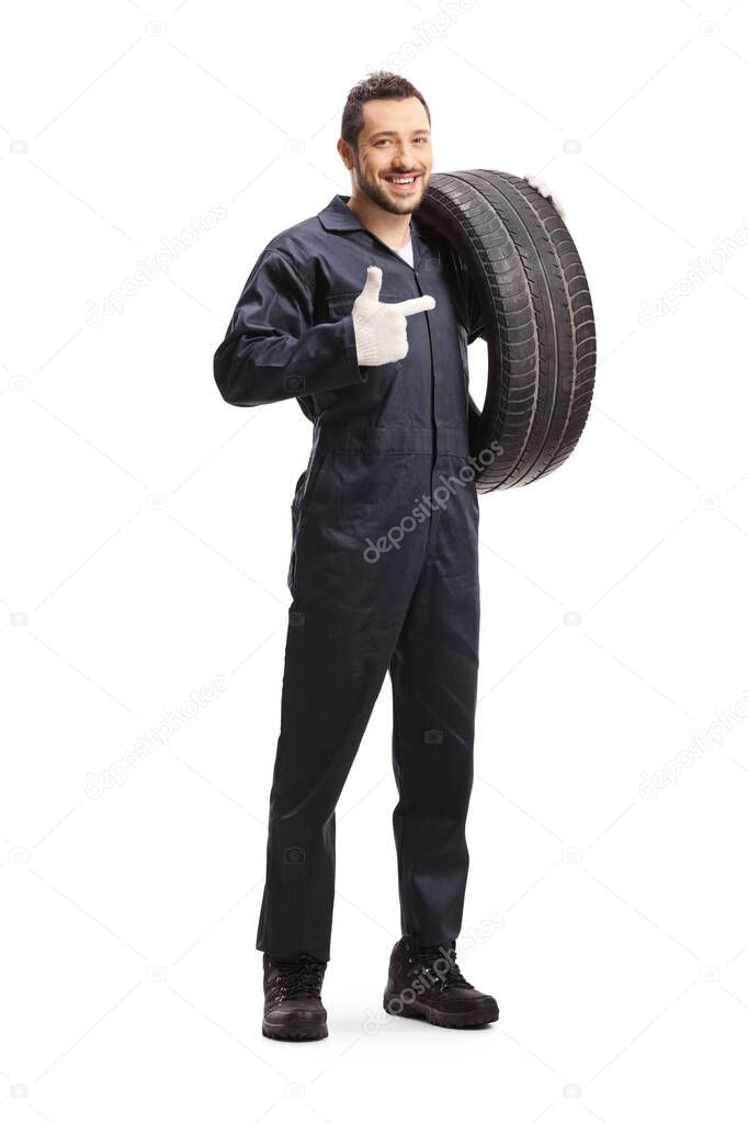Mechanic holding a of car tire and pointing