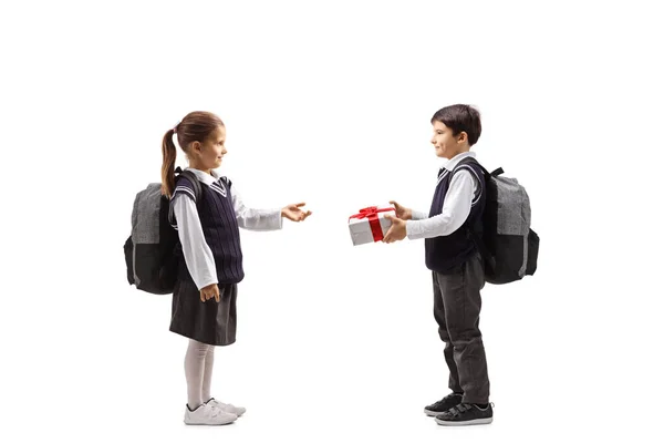 Schoolboy giving apresent to a schoolgirl — Stock Photo, Image