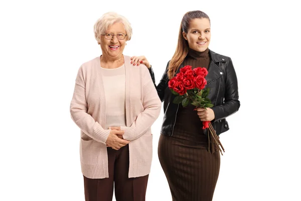 Внучка держит букет роз и стоит рядом с ней. — стоковое фото
