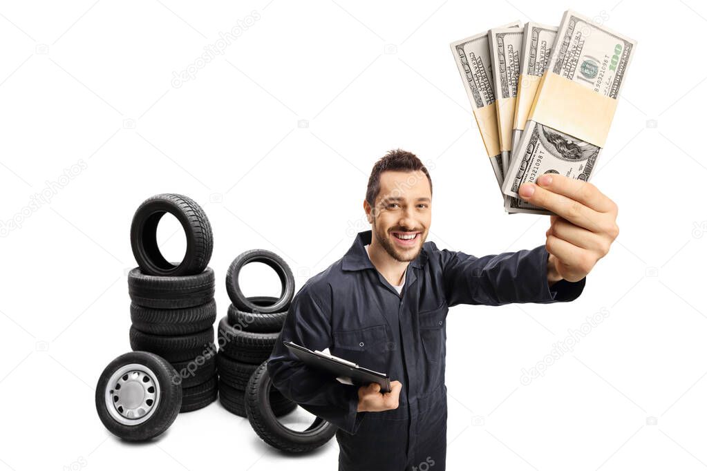 Auto mechanic with a clipboard holding stacks of money and tires