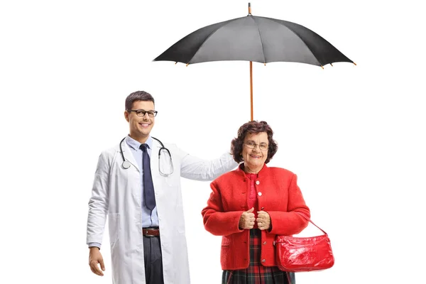 Доктор держит зонтик над пожилой женщиной — стоковое фото