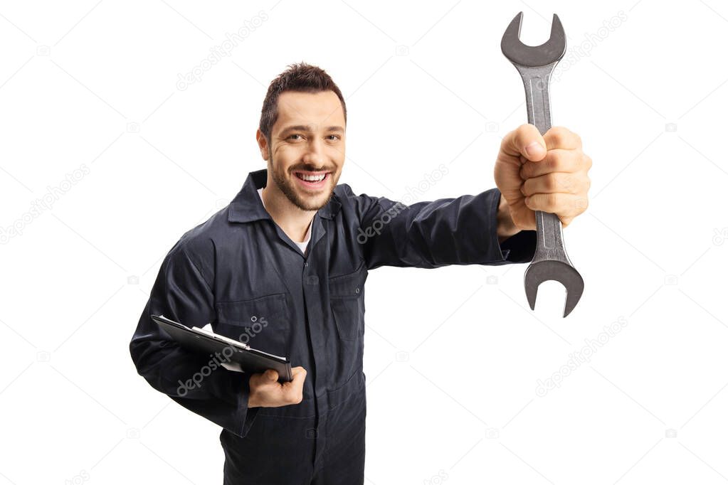 Auto mechanic holding a wrench and a clipboard and smiling at th