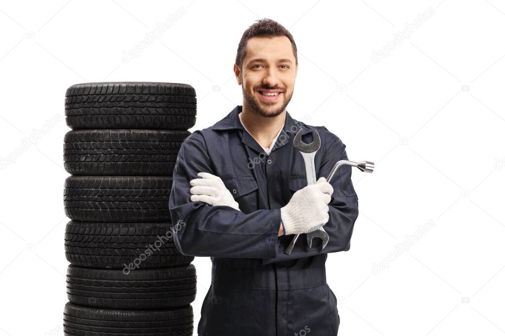 Auto mechanic holding car repair equipment and posing with a pil