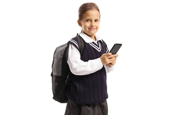 Školačka v uniformě s batohem v ruce smartphone — Stock fotografie