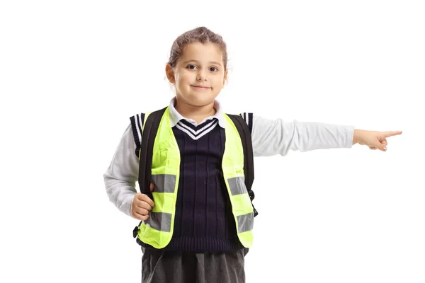 Pequena estudante vestindo colete de segurança de pé e apontando — Fotografia de Stock