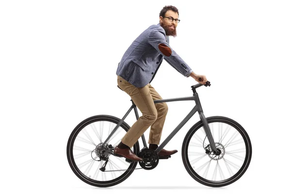 Tipo barbudo montando una bicicleta y mirando a la cámara — Foto de Stock