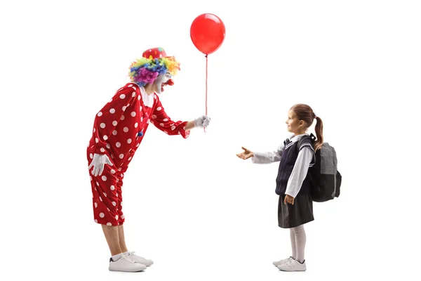 Clown giving a red balloon to a schoolgirl — Stock Photo, Image