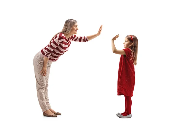 Genç bir kadın kırmızı elbiseli bir kızla beşlik çakıyor. — Stok fotoğraf