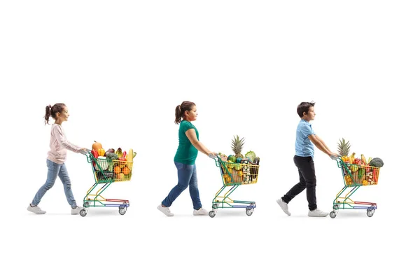 Tres niños con carritos de compras llenos de comida sana waling i —  Fotos de Stock