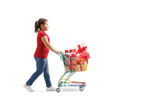 Meisje dat een mini winkelwagentje duwt met geschenkdozen — Stockfoto