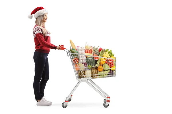 Młoda kobieta z wózkiem zakupy żywności na święta Bożego Narodzenia — Zdjęcie stockowe