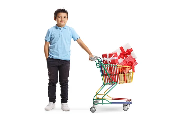 Junge posiert mit Einkaufswagen mit Geschenken — Stockfoto