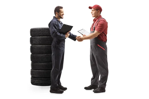 Auto mechanic shaking hands with a delivery man — Stock Photo, Image