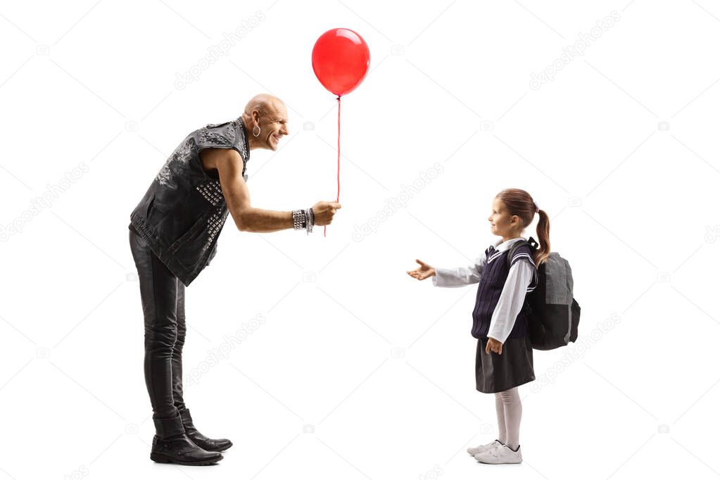 Punker in leather clothes giving a red baloon to a schoolgirl