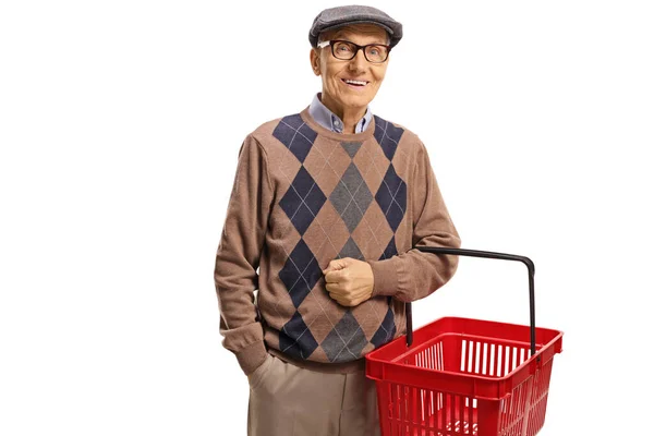 Elderly man smiling and holding a shopping basket — Stock Photo, Image