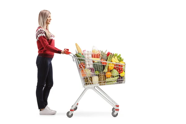 Mulher com comida em um carrinho de compras — Fotografia de Stock