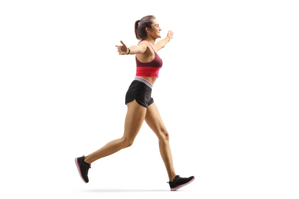 Glückliche junge Frau joggt und breitet die Arme aus — Stockfoto