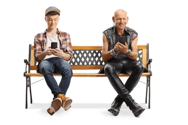 Punker feliz y un chico joven en un banco con teléfonos inteligentes —  Fotos de Stock