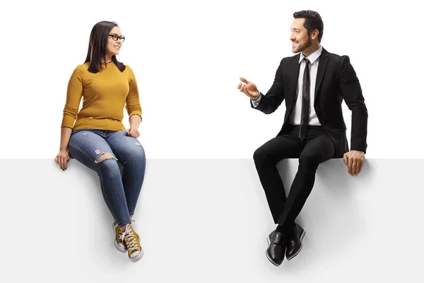 Бізнесмен розмовляє з молодою жінкою і сидить на панелі — стокове фото