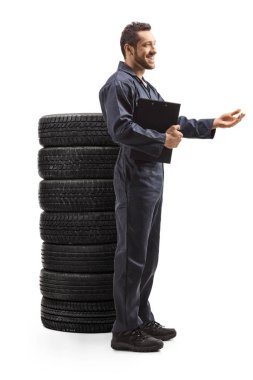 Otomobil tamircisi bir yığın lastikle ayakta duruyor.